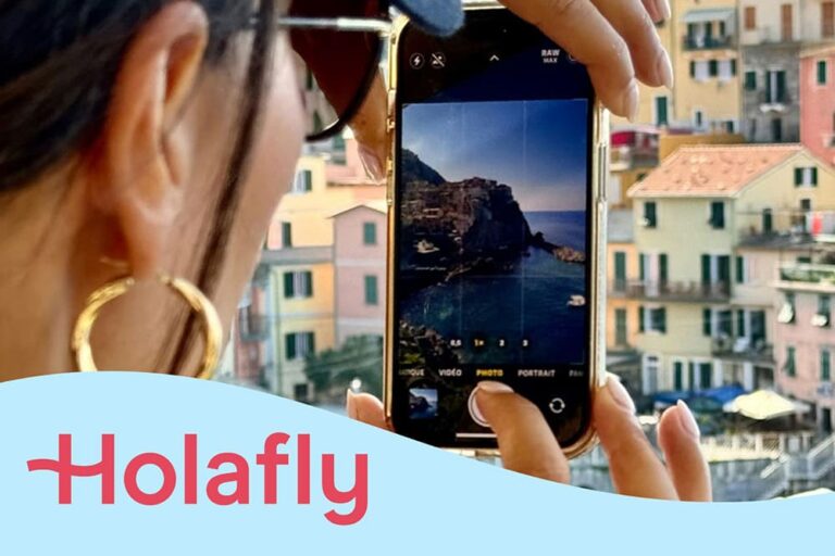 スマホでイタリアの街並みを撮影している女性の写真