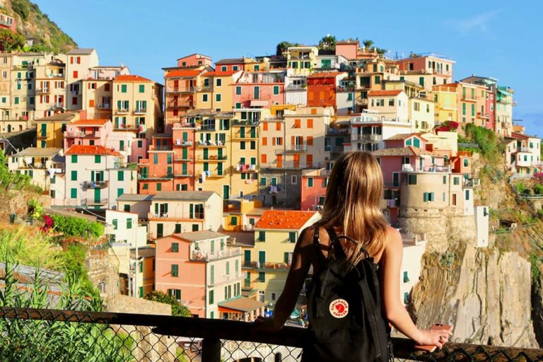 夏用ノースリーブを着た女性がイタリアの街を眺めている写真