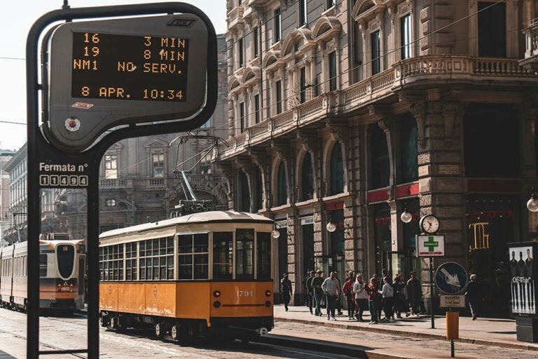 イタリアの街を走る黄色と白のトラムの写真