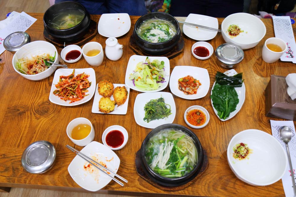 韓国の伝統的な定食「韓定食（ハンジョンシク）」。スープや煮物、新鮮な野菜のおかずが豊富に並び、栄養バランスのとれたヘルシーな食事。