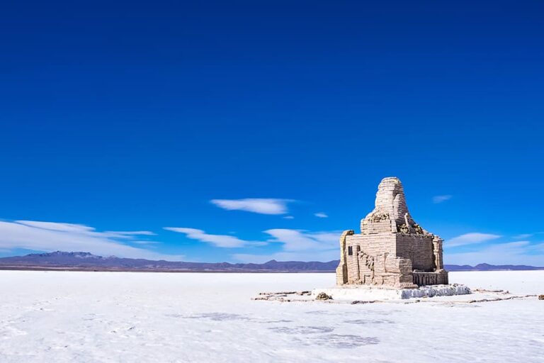 乾季のウユニ塩湖に佇む石造りの廃墟と真っ白な塩原の絶景