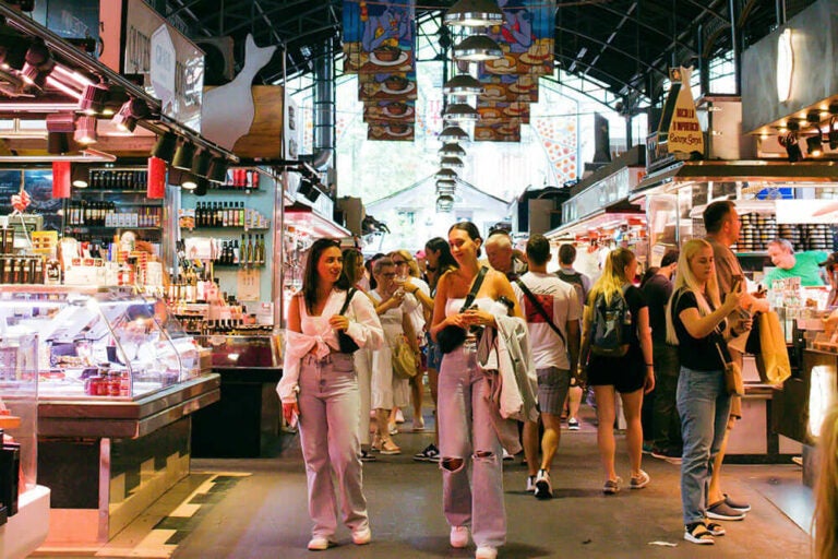 ランブラス通りのボケリア市場で買い物を楽しむ観光客の写真