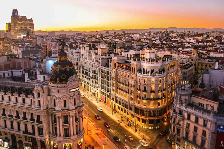 夕焼けの空とオレンジの光が灯り始めたマドリードの街並み