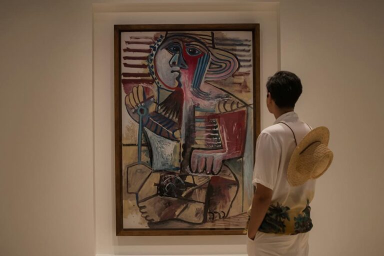 ピカソ美術館で絵画を見学する人の写真