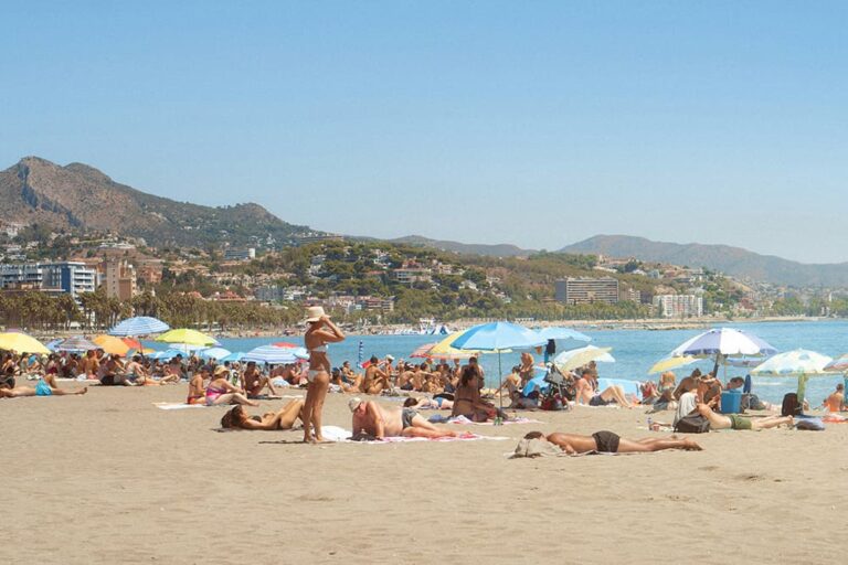 スペインのビーチで日光浴を楽しむ人々の写真