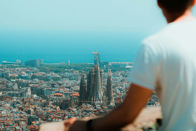 サグラダファミリアを高台から見下ろす男性の後ろ姿の写真