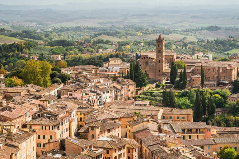 初夏のトスカーナ地方・シエナの旧市街と丘陵地帯を望む街並みの風景写真