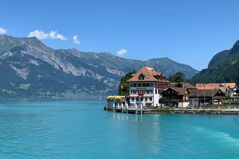 8月のスイス・インターラーケン、アルプスの山々と湖畔のホテルが並ぶ静かな避暑地の風景