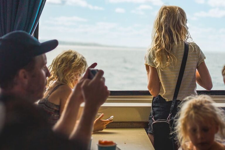 7月の海外旅行で船内から海を眺める家族連れ
