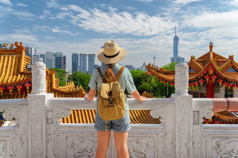天后宮の境内からクアラルンプールの高層ビル街を眺める女性旅行者の後ろ姿