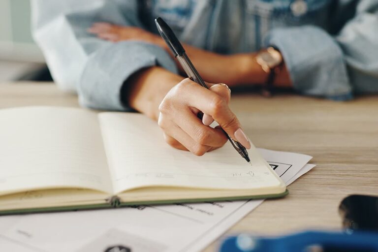 2026年のお盆休みの連休日程をノートに書き込みながら海外旅行を計画する様子