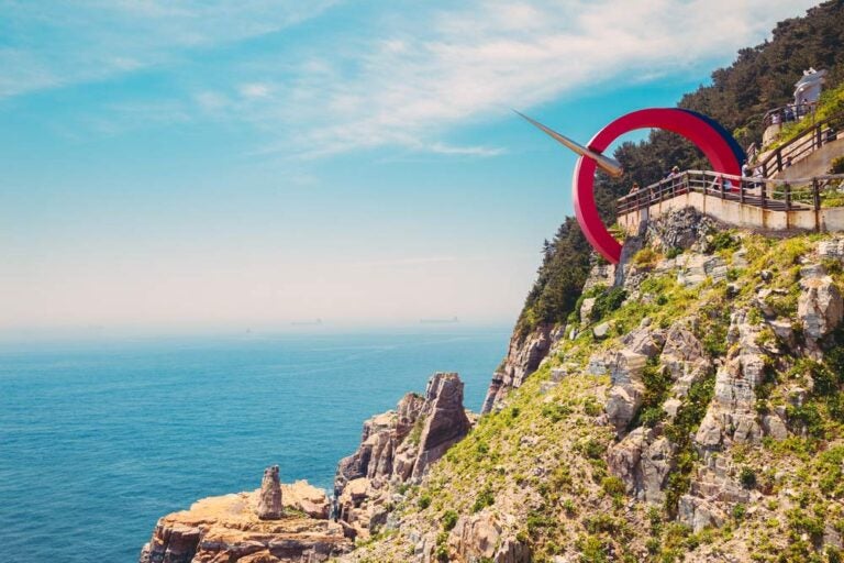 韓国・釜山の太宗台で、断崖絶壁の上に建つ「希望の針」モニュメントと広がる青い海。ダイナミックな自然と展望台からの雄大な景色が楽しめる名所。