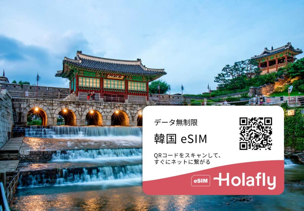 韓国・水原の世界遺産「華城」にある華虹門を背景にしたHolaflyの韓国eSIM広告。滝のような水流と伝統建築が美しく調和し、右下にはQRコードと「データ無制限 韓国eSIM」の案内が表示されている