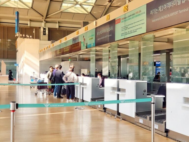 韓国・仁川国際空港第1ターミナルのチェックインカウンターの様子。旅行客がカウンターに並び、荷物を預ける様子が明るい光の差し込む空間で撮影されている。