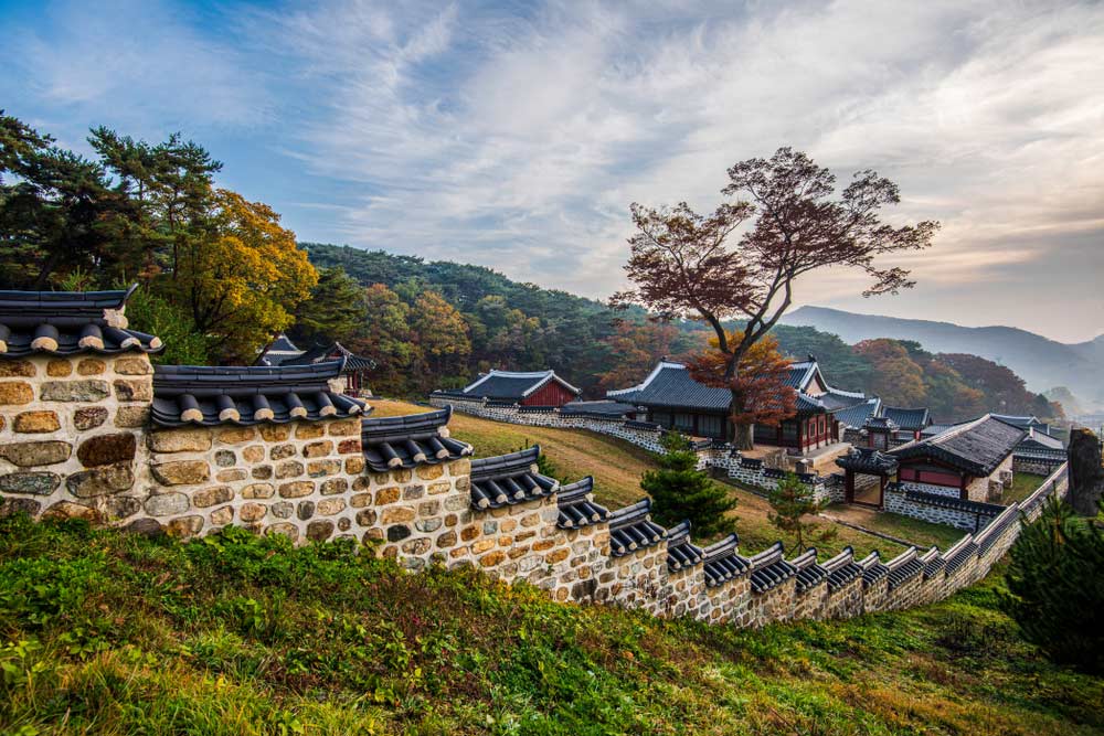 秋色に染まる南漢山城(ナムハンサンソン)の石垣と伝統的建築。歴史を感じさせる静かな山城の風景。