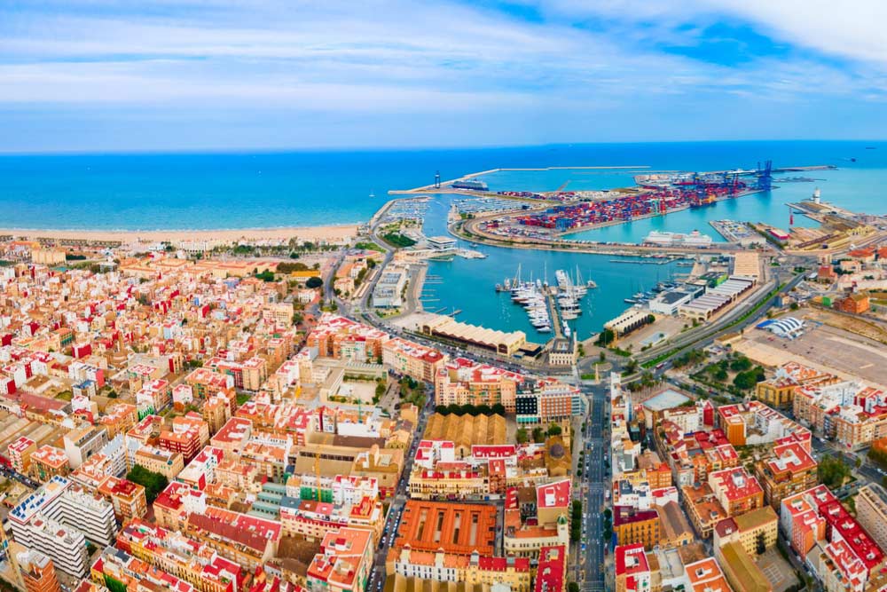 スペイン・バレンシアの港と街並みを一望できる空撮写真。地中海に面した活気ある都市の景色が広がる。