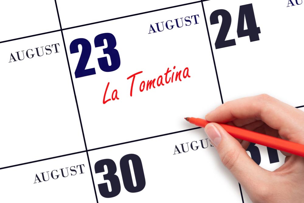 8月23日のカレンダーに「La Tomatina(ラ・トマティーナ)」と赤いペンで書き込まれた予定。スペインのトマト祭りの日程を示すイメージ。