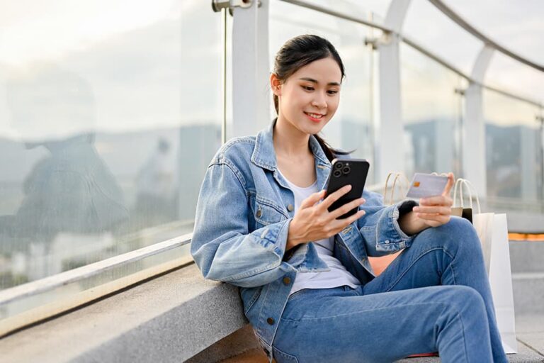 台湾旅行後に余った現金の対処法をスマートフォンで調べる女性