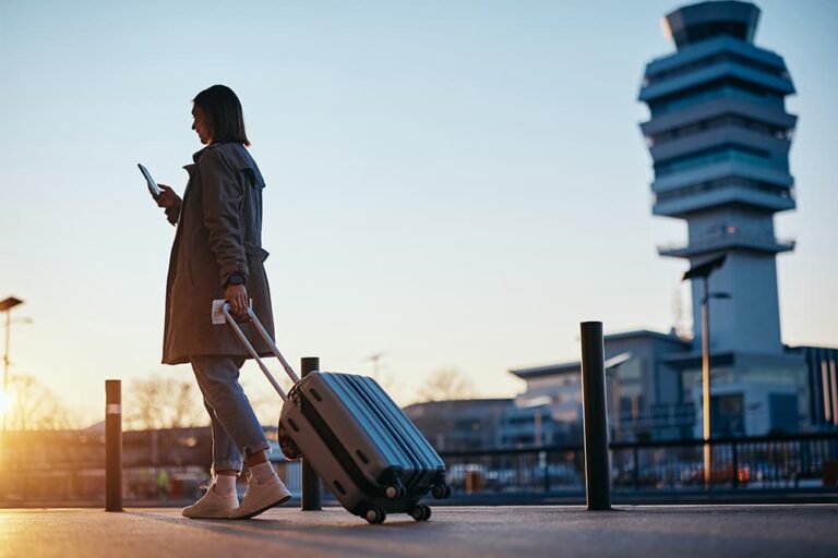 アメリカ旅行出発前にスマホを確認しながら空港を歩く女性旅行者