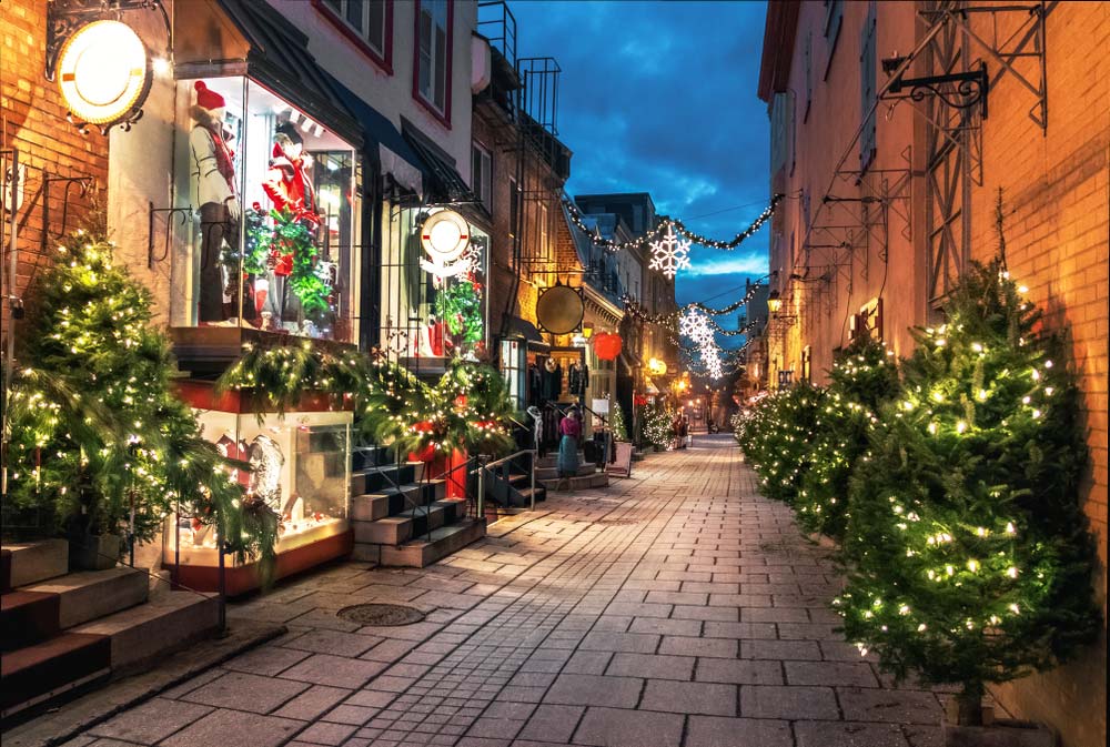 カナダ・ケベック旧市街の石畳の街並みがクリスマスイルミネーションで彩られた夕暮れの風景