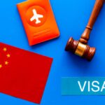中国国旗、ビザ、パスポート、判子（ガベル）が青い背景に並べられた、中国ビザや入国審査をイメージしたコンセプト画像。