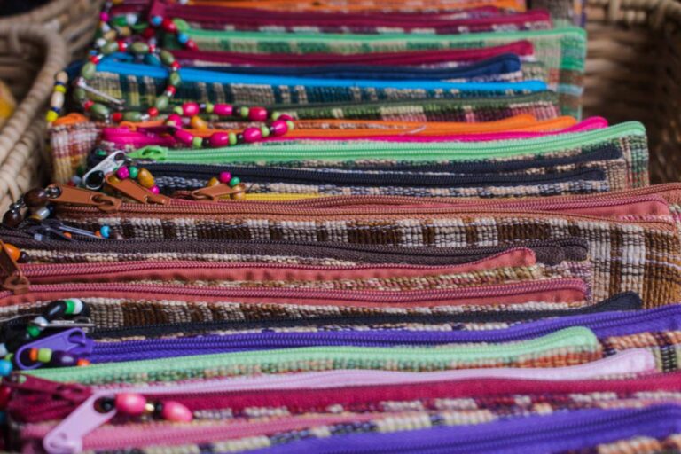 フィリピンの市場で並べられた、カラフルなビーズ付きファスナーの手織りポーチ。お土産に人気のアイテム。
