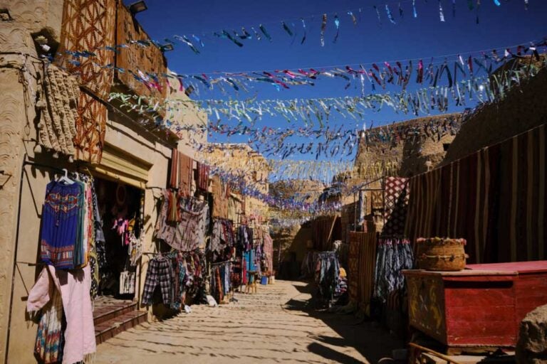 エジプト・シワオアシスにある伝統的な土産物市場、色とりどりの布や民族衣装が並び、ローカルな雰囲気漂うおすすめのショッピングスポット