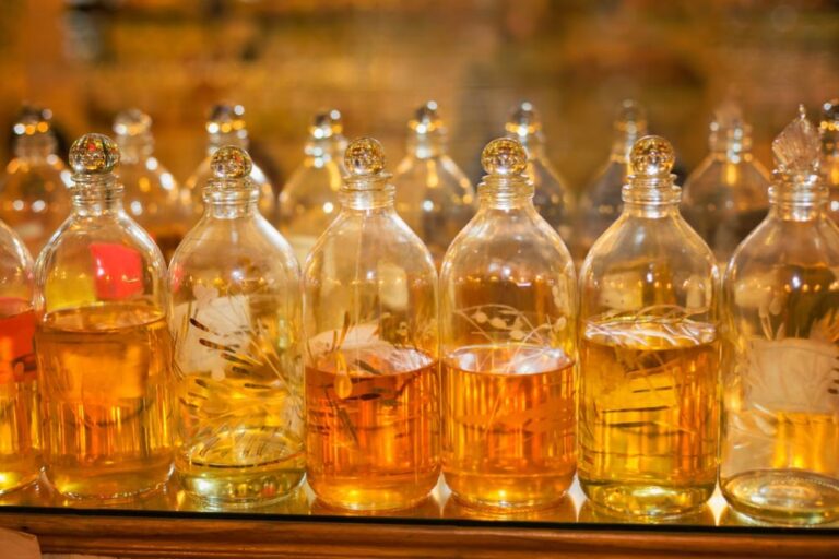 エジプトの市場で売られている装飾入りのガラス瓶に入った香油が、オレンジや金色に輝いて整然と並べられている。