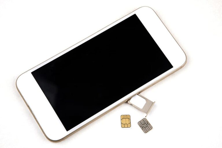 スマートフォンから取り外した物理SIMカードと空のSIMトレイ。eSIMへの変更後、不要になったSIMカードを処分する場面