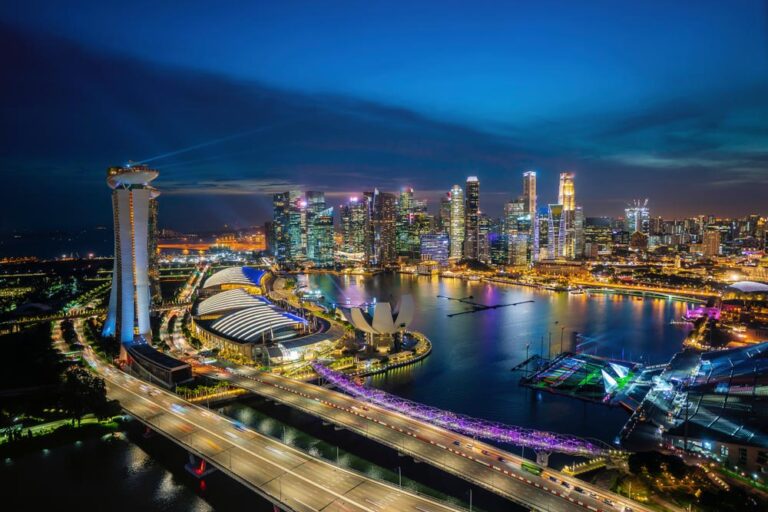 夜景に輝くシンガポールのマリーナベイと高層ビル群、光に照らされた橋と観光施設が美しく映える安全で活気ある夜の都市風景