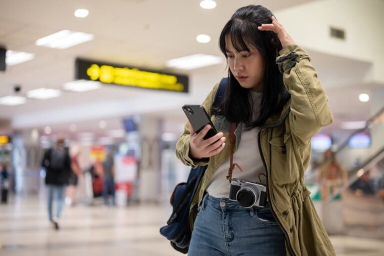 韓国の空港でスマートフォンの接続状況を確認する旅行者。eSIM利用前の注意点を確認する場面