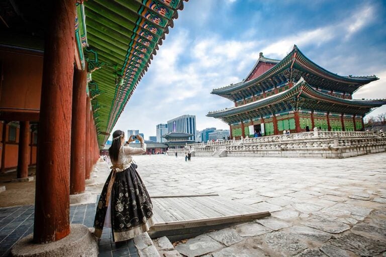 ソウルの景福宮でスマートフォンを使う旅行者。4日間の韓国旅行でeSIMを利用する場面