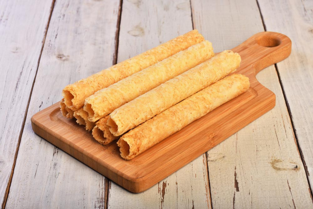 サクサクとした食感が特徴の台湾エッグロールクッキーが木製カッティングボードに並べられている様子。
