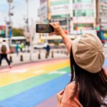 台湾・台北の西門町にあるレインボーカラーの横断歩道でセルフィーを撮っている女性の後ろ姿。