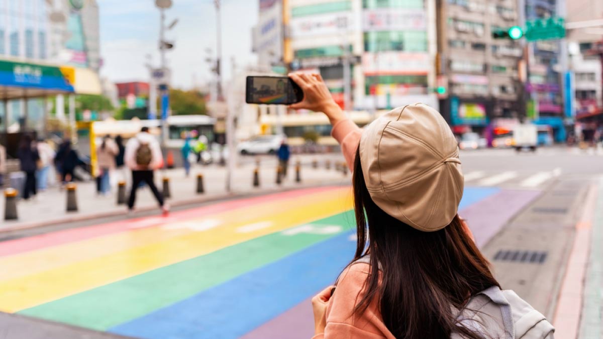 台湾・台北の西門町にあるレインボーカラーの横断歩道でセルフィーを撮っている女性の後ろ姿。