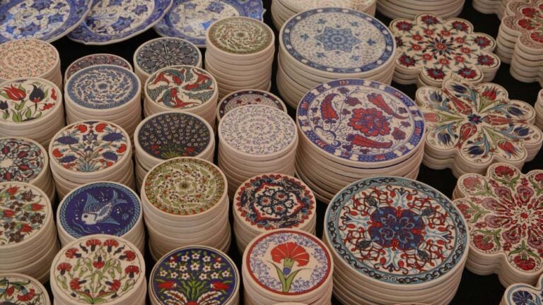 トルコの伝統的なイズニック模様が描かれたカラフルな円形や花形のセラミックコースターが、並べられている様子。