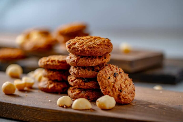 ハワイの定番土産、マカダミアナッツ入りクッキーが木製プレートに美しく積み重ねられた様子。ばらまき用としても人気の高いハワイ産スイーツ。