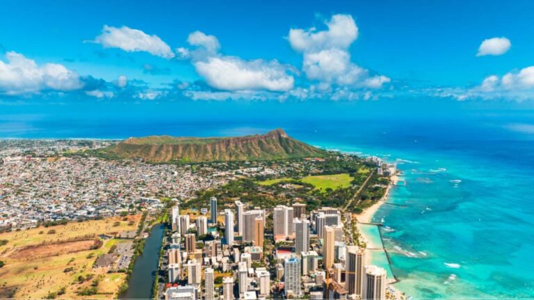 青く澄んだ海とワイキキの高層ホテル群、背後にそびえるダイヤモンドヘッドが象徴的なオアフ島の空撮風景