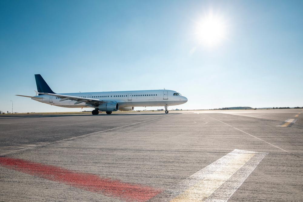 青空の下、滑走路で待機する旅客機。