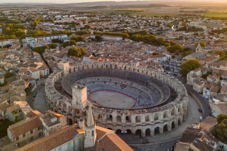 フランス・アルルの旧市街に残るローマ時代の円形闘技場を上空から撮影した写真。世界遺産に登録されたローマ遺跡群とロマネスク建築が調和する歴史的都市の魅力を伝える一枚。