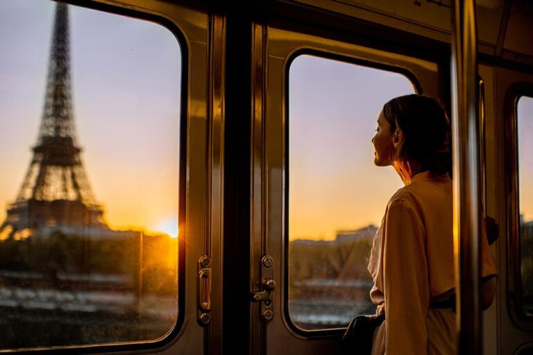 9月の海外旅行におすすめのパリで、夕暮れのエッフェル塔を窓越しに眺める旅行者の横顔