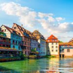 ストラスブール旧市街・プティット・フランス地区の運河沿いに並ぶ木組みの家々を望む風景写真