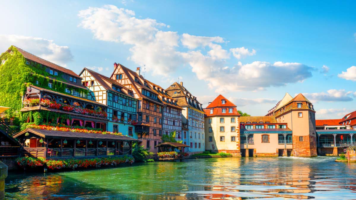 ストラスブール旧市街・プティット・フランス地区の運河沿いに並ぶ木組みの家々を望む風景写真