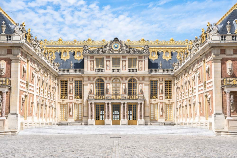 フランスの世界遺産ヴェルサイユ宮殿の豪華な外観を正面から写した写真。ルイ王朝の栄華を感じる建築美と庭園観光の魅力を伝える一枚。