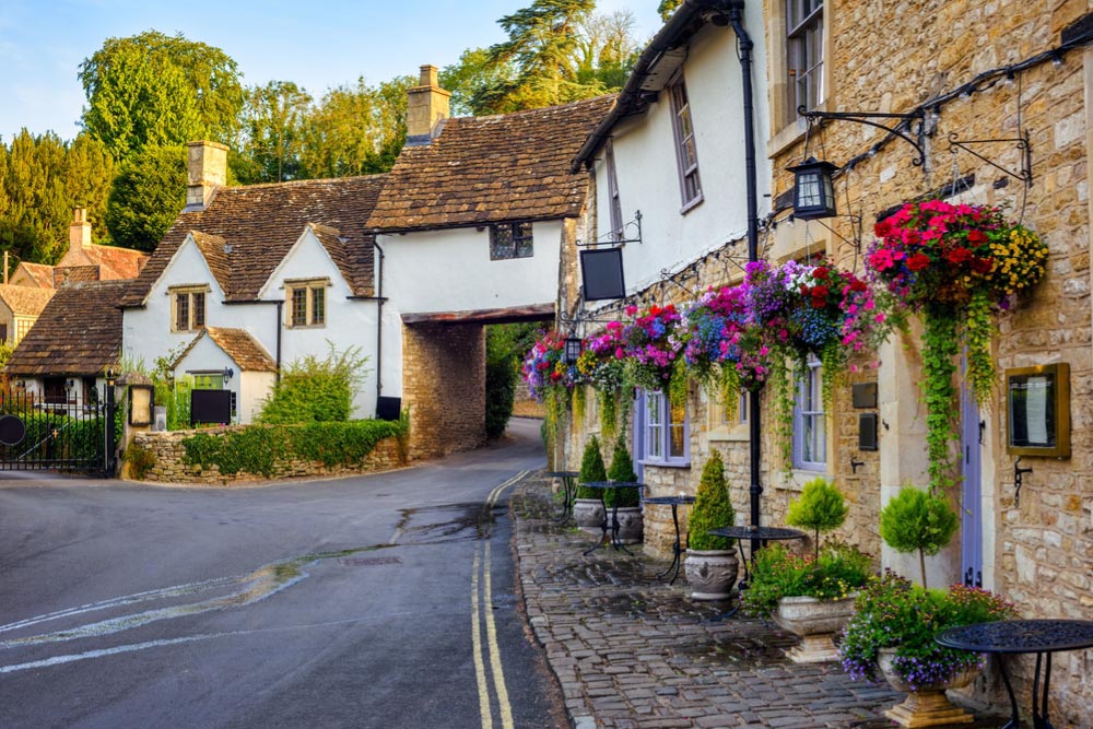 イギリス・コッツウォルズの伝統的な村の街並みと花飾りの家
