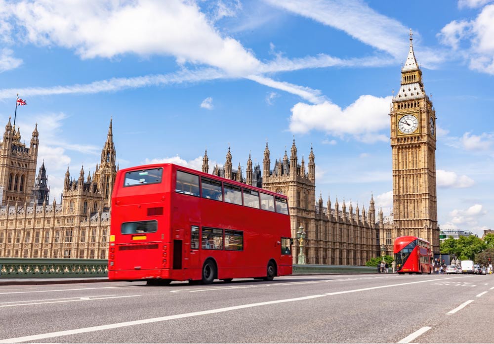 ロンドン市内を走る赤い2階建てバスとビッグ・ベンを写した写真。