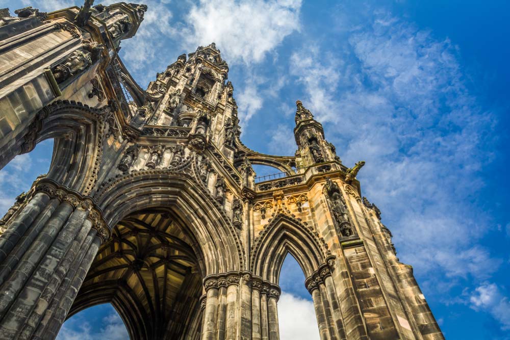 青空を背景にそびえ立つエディンバラのスコット記念塔を見上げた写真