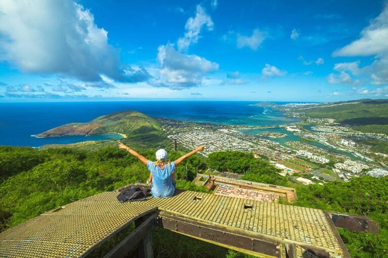 9月の海外旅行におすすめのオアフ島で、展望スポットから青い海と街並みを見渡す旅行者の後ろ姿