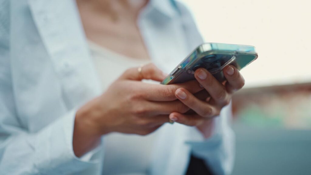 スマートフォンを操作する女性の手元のクローズアップ