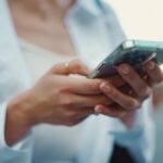 スマートフォンを操作する女性の手元のクローズアップ
